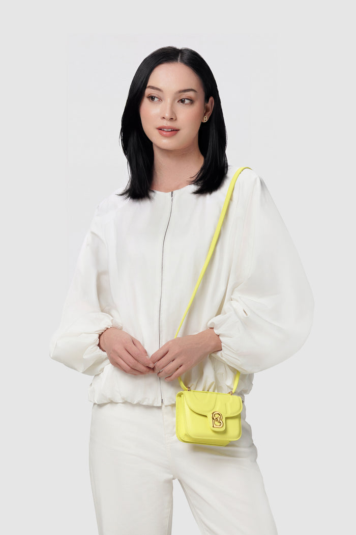 alba bag mini yellow worn by a woman