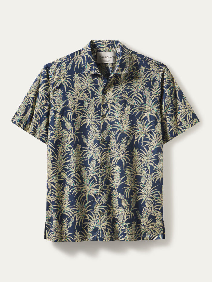 Navy shirt with beige and green tropical leaf and pineapple print, front view.