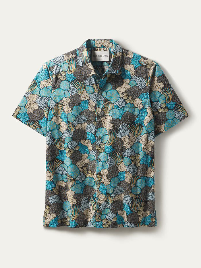 Multicolored short-sleeve cotton lawn shirt with blue, black, and beige abstract floral print, flat lay front view.