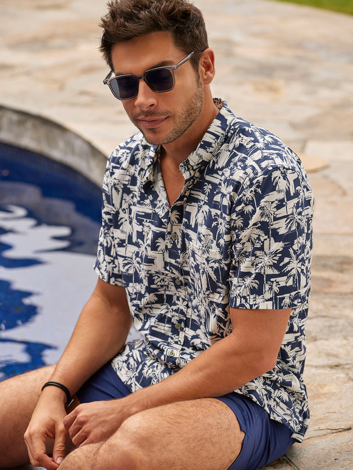 Blue solid moisture-wicking short-sleeve shirt, man seated poolside, front view.