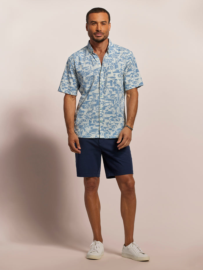 Light blue and white tropical-print short-sleeve shirt and navy shorts, full front view.