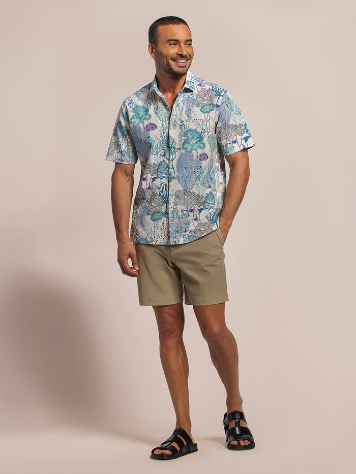 Aquatic white/blue solid sun shirt with tan shorts and black sandals, full front view.