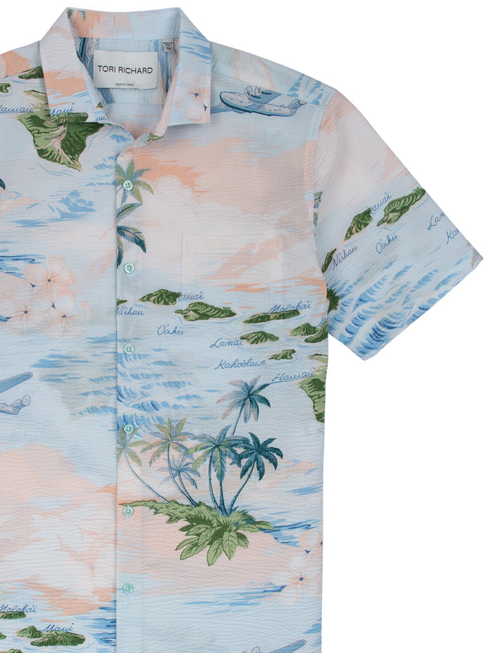 Pastel palm and wave-print cotton lawn tall shirt with planes and island names, front view.