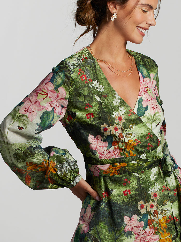 Green floral-print wrap dress, three-quarter sleeves, side view of smiling woman.