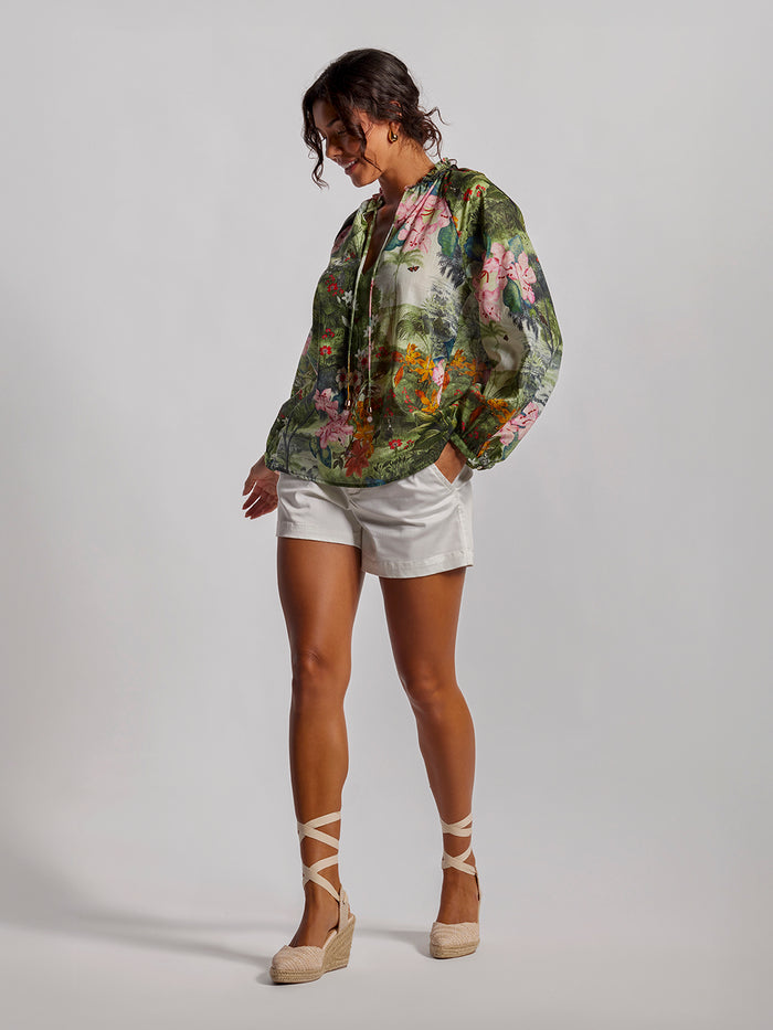 Multicolor print blouse, white shorts, tan espadrilles, front view on gray background.