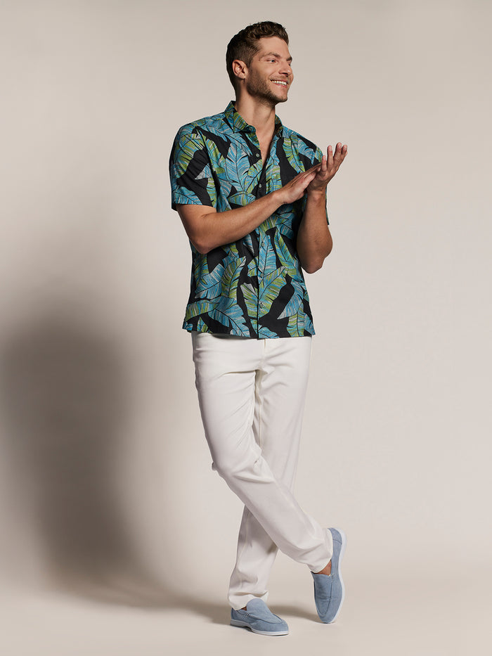 Blue and yellow banana-print short-sleeve shirt, white pants, front view