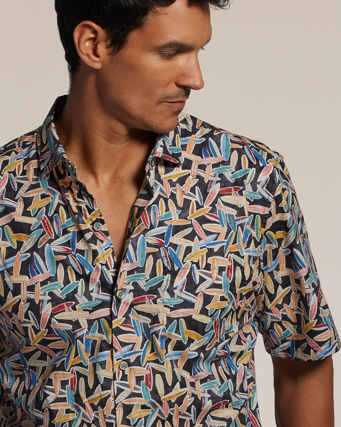 Red, yellow, and blue surfboard-print short-sleeve shirt, front view on a model.