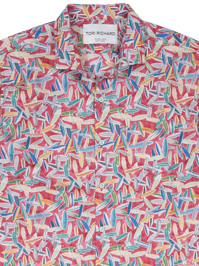 White shirt with colorful surfboard print, short sleeves, front and angled views, Hawaiian style.