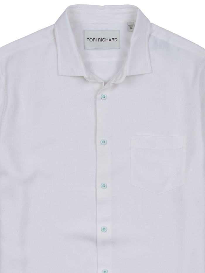 White solid silk-Tencel shirt with chest pocket, blue buttons, and visible neck tag, front view.
