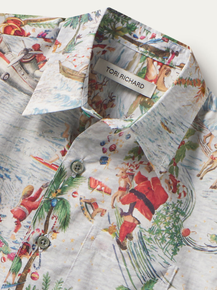 {{Red, green, and white Santa and palm print cotton short-sleeve shirt, close-up of fabric detail}}{{/AltText}}.