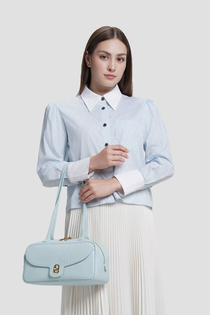 bria shoulder bag in baby blue by buttonscarves carried on wrist