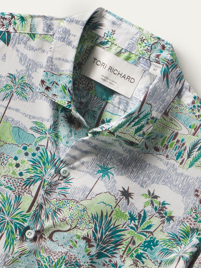 White shirt with green and brown palm tree landscape nature print, front view.