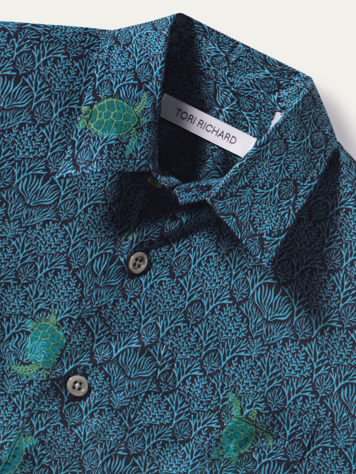 Blue cotton shirt with green sea turtle print, button-down front view.