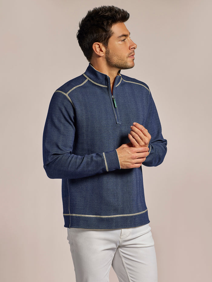 Navy quarter-zip pullover with white contrast stitching, side view against neutral background.