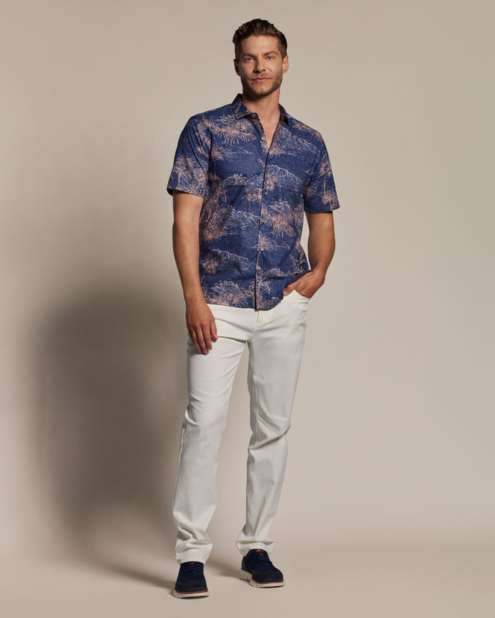Blue patterned short-sleeve shirt with white pants, front view, hand in pocket (Images 1 & 2).