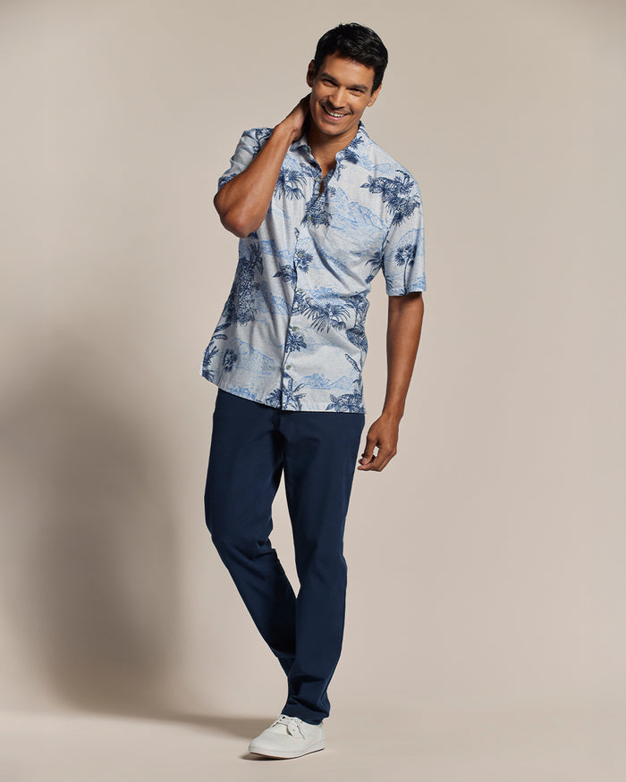 Light blue patterned short-sleeve shirt, navy pants, and white sneakers, front view.