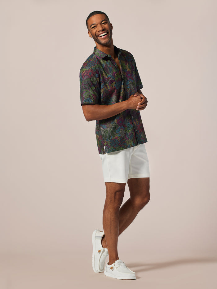 Multicolored short-sleeve shirt, white shorts, sneakers, front view.