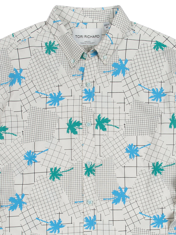 Cream long-sleeve button-down with black grid and blue-green palm print, front view.