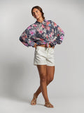 Coral floral-print relaxed-fit blouse, front view, with white shorts and sandals.