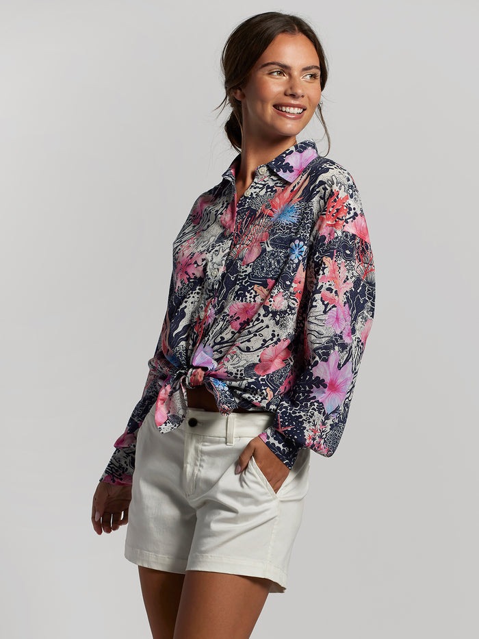 Coral floral-print Leslie top with white shorts, hand in pocket, front view.