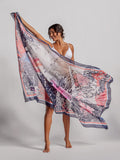 Coral floral-print pareo wrap, held by model in white bikini, front view.