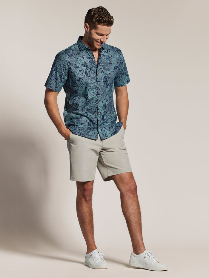 Blue patterned short-sleeve shirt, light shorts, and white sneakers, full body front view in both images.