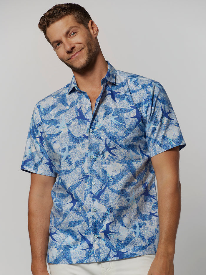 Blue Hawaiian seabird-print cotton lawn short-sleeve shirt, worn by a smiling man, front view.