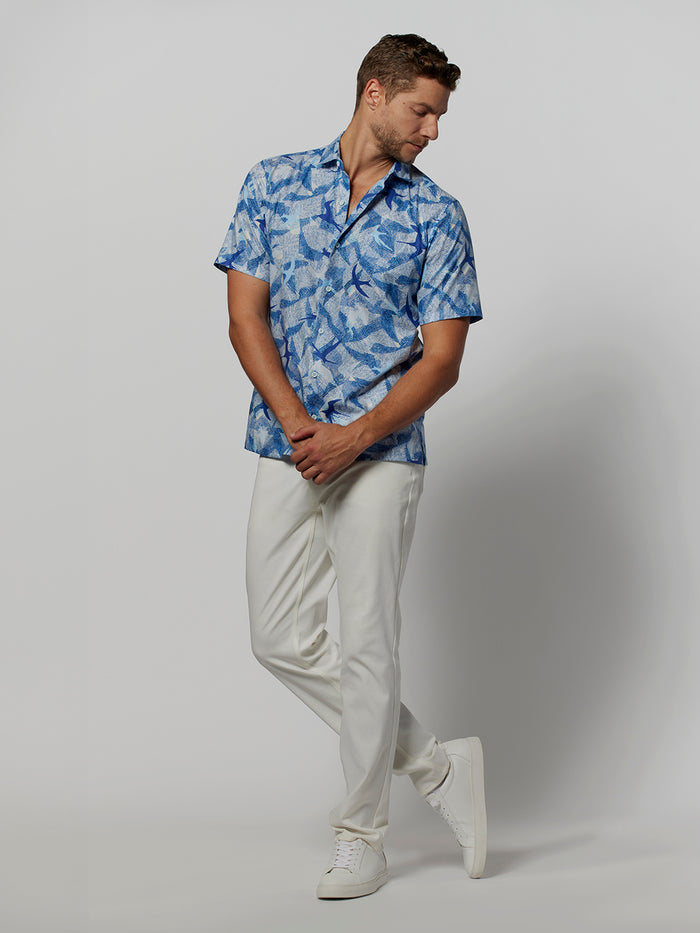 Blue tern-print cotton short-sleeve shirt, front view, man standing with hands clasped.