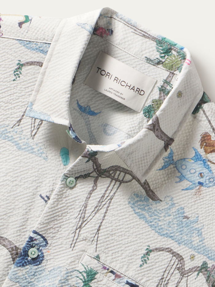 Blue animal and tree-print short-sleeve shirt with 2-button collar, front view.
