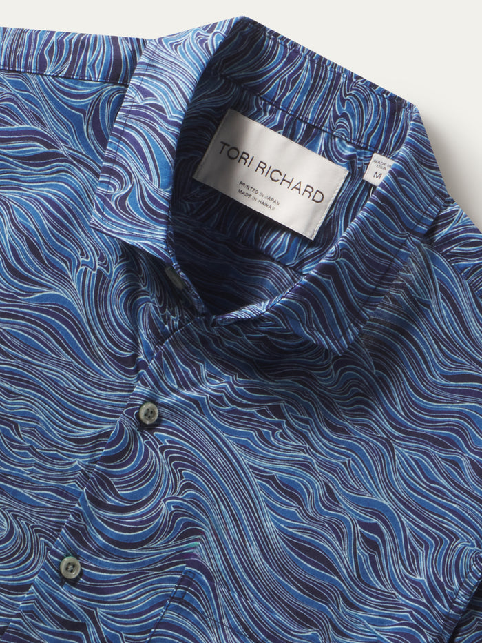 Blue and white swirling wave-print cotton shirt shown in two close-up fabric detail images.