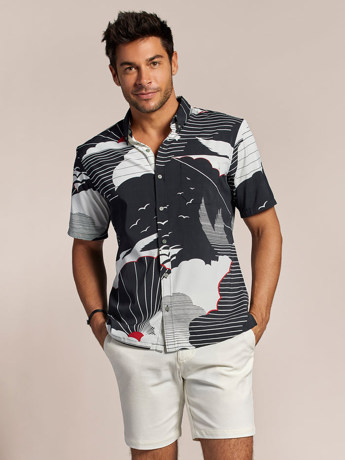 Black cloud/sunburst with red accent-print short-sleeve shirt front view, hands in pockets.