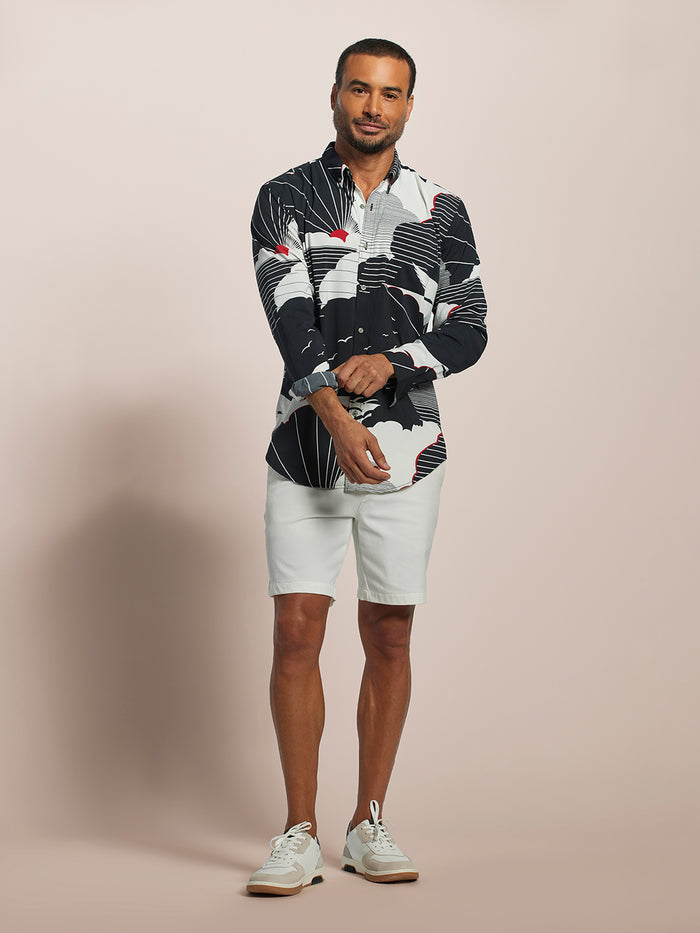 Black/white with red accent abstract-print long-sleeve shirt with Tradewind Technology, man adjusting sleeve, front view.