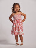Coral smocked-bodice Adalei dress, front view; girl poses hands on hips.