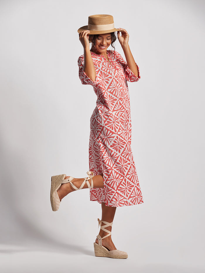 White and pink patterned caftan dress, full view, with espadrille wedges and straw hat.