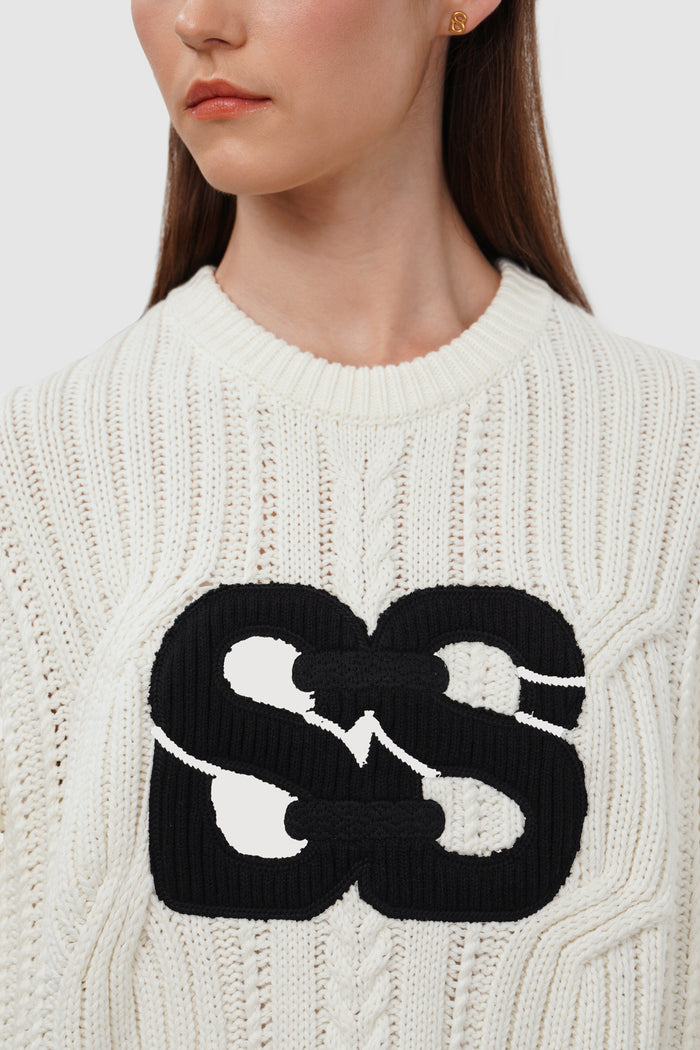 deux knit sweater in ivory by buttonscarves logo patch detail