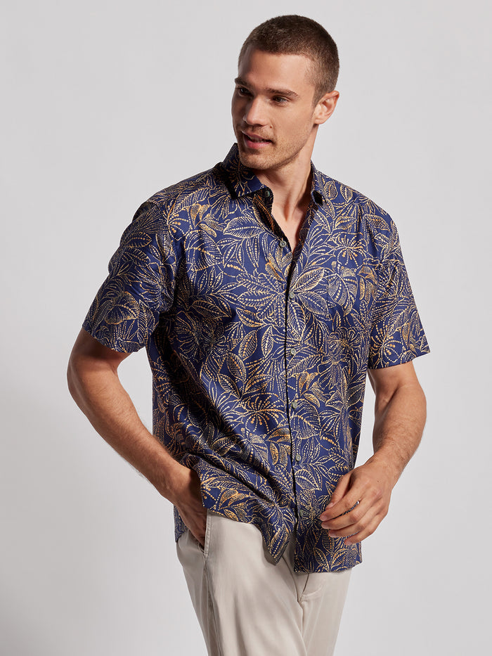 Blue leaf-print short-sleeve shirt, front view with hand in pocket of a model.