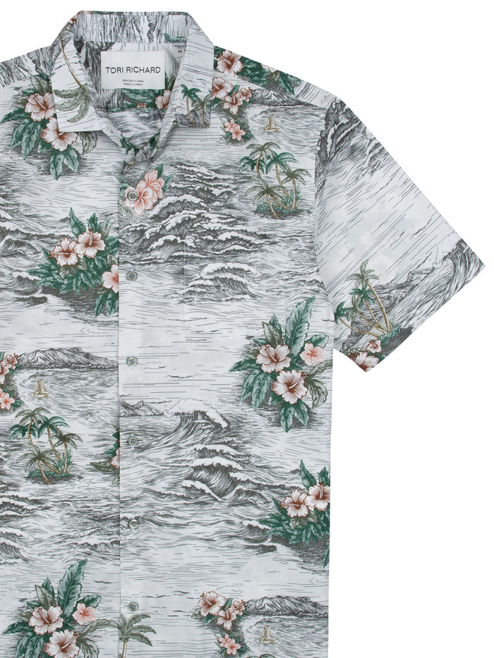 Front of white Hawaiian shirt with pink floral, palm tree, and wave print.
