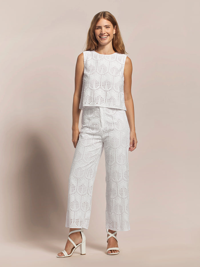 White sleeveless crop top and white palm eyelet pants, front view.