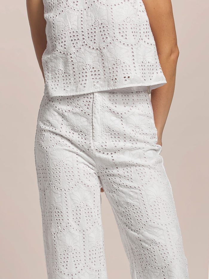 White eyelet sleeveless top with white palm-patterned Phoebe pants, front view.