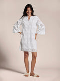 White palm eyelet knee-length dress, sleeveless, front view with sandals.
