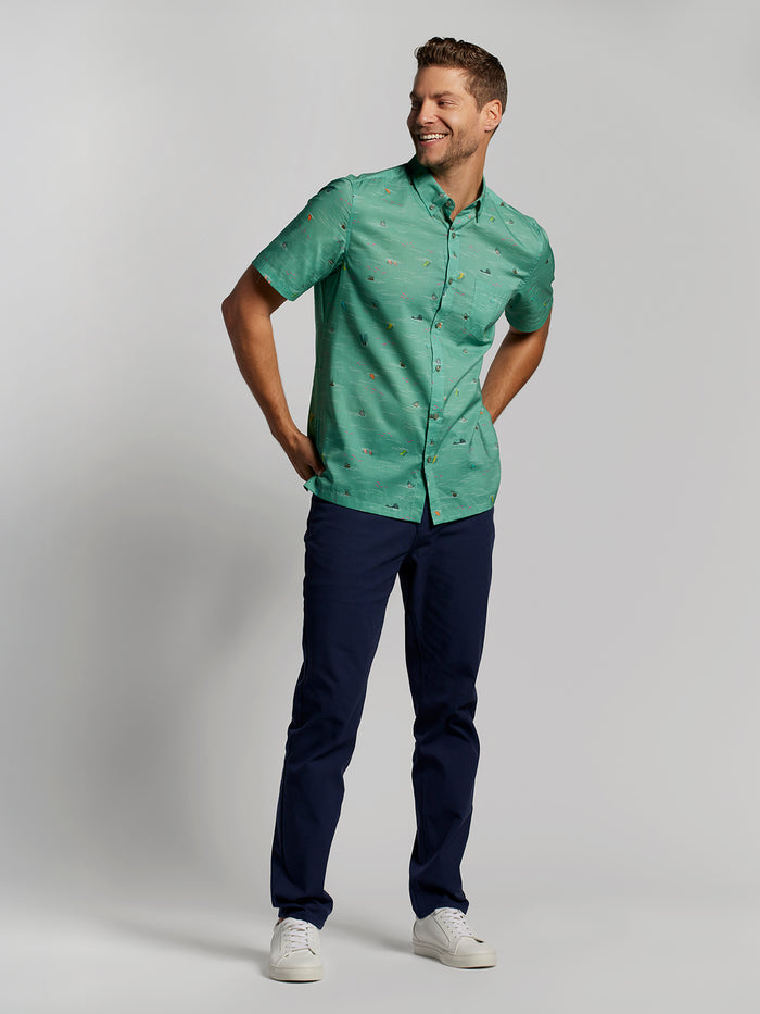 Green graphic short-sleeve shirt, navy pants, white sneakers, front view shown in Images 1 and 2.