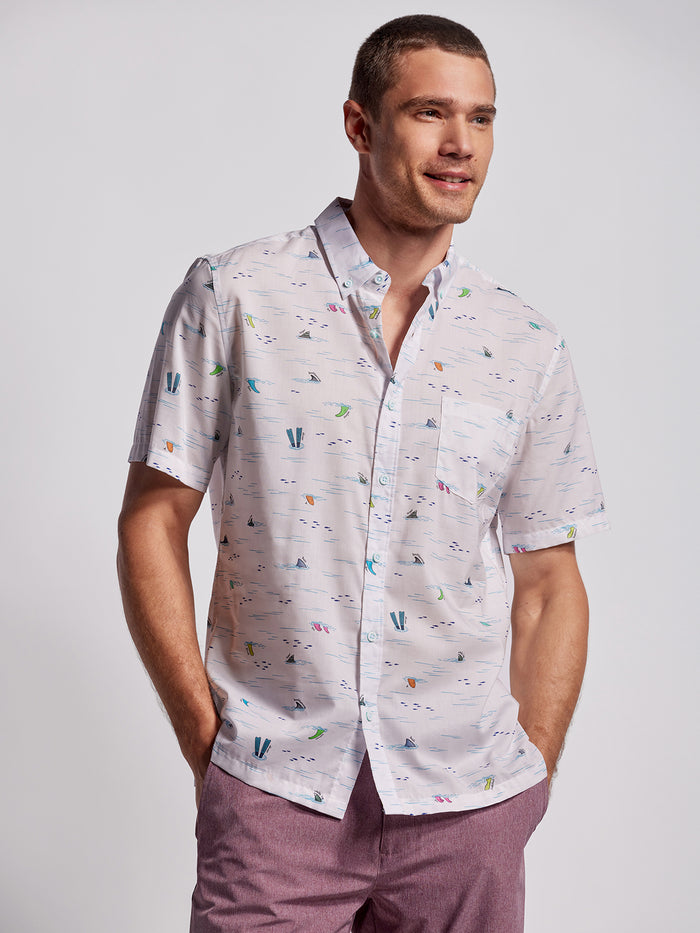 White sailboat-print short-sleeve shirt and light purple shorts, front view.