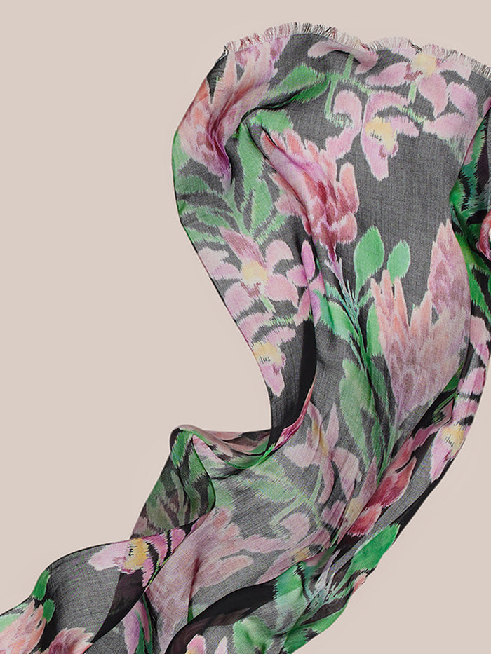 Black sheer scarf with vivid pink, green, and white orchid flowers on beige, back view.