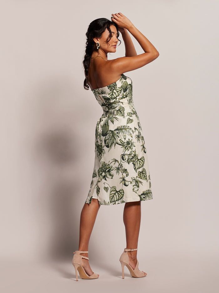 White and green leaf-print strapless midi dress, front view, arms raised.