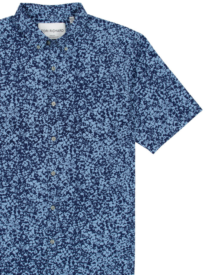 Floralia blue short-sleeve shirt with navy floral print, front view on white backdrop.
