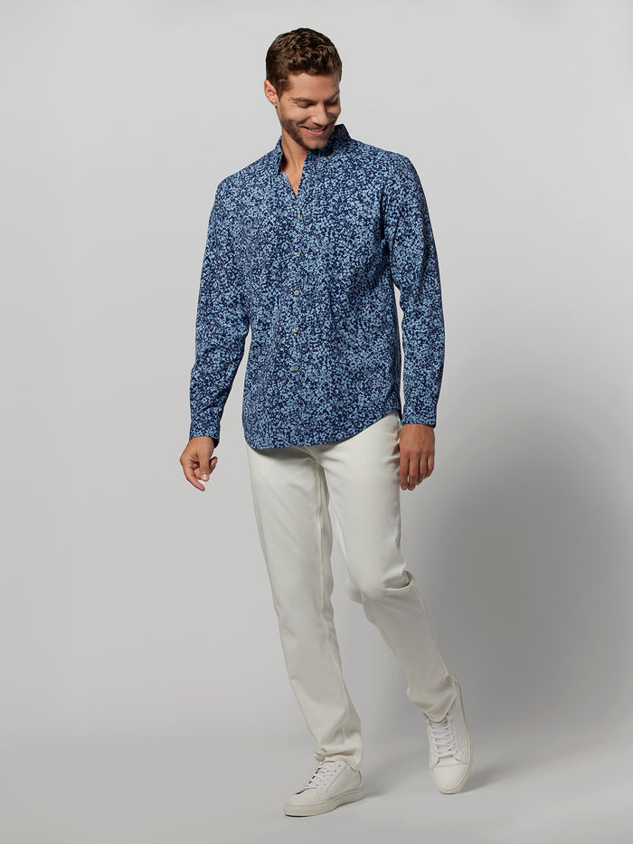 Floral-print blue long-sleeve shirt, front view, paired with white pants and shoes.