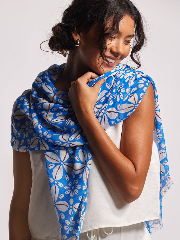 Blue and white floral-print scarf, woodblock-inspired design, light background, worn by woman.