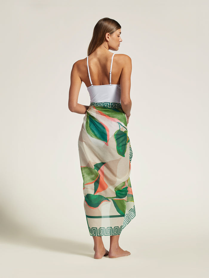 White sleeveless top and green-leaf print pareo wrap skirt, back view.
