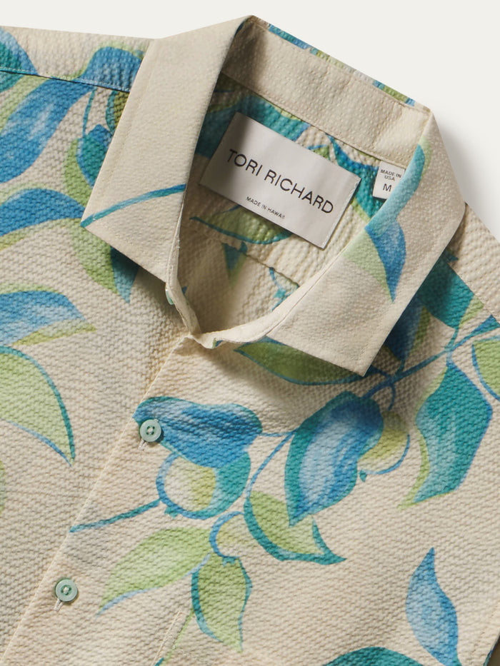 Beige short-sleeve shirt with blue and green leaf print, close-up of collar and Tori Richard label.