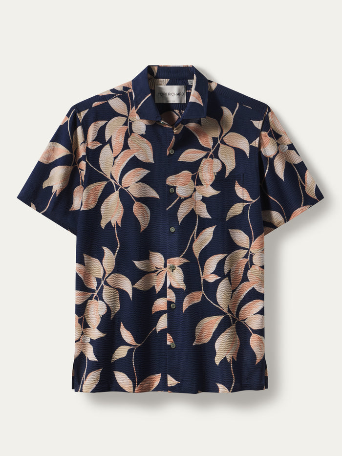 Navy short-sleeve shirt with peach and beige leaf print, shown in front view.